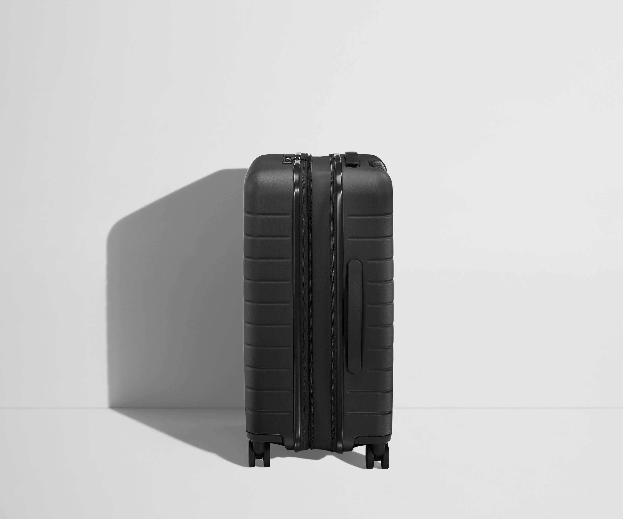 Side product view of The Bigger Carry-On Flex suitcase in Jet Black shown fully expanded