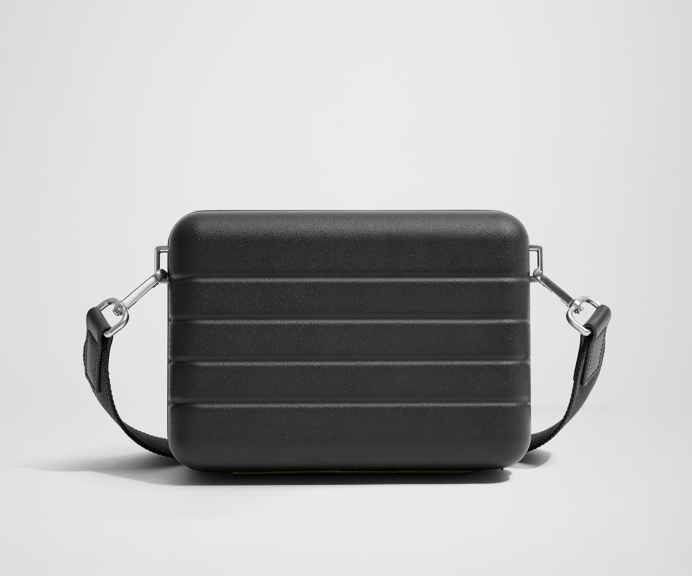 Unzipped, open view of The Mini Crossbody, showing the two main compartments and slip pocket