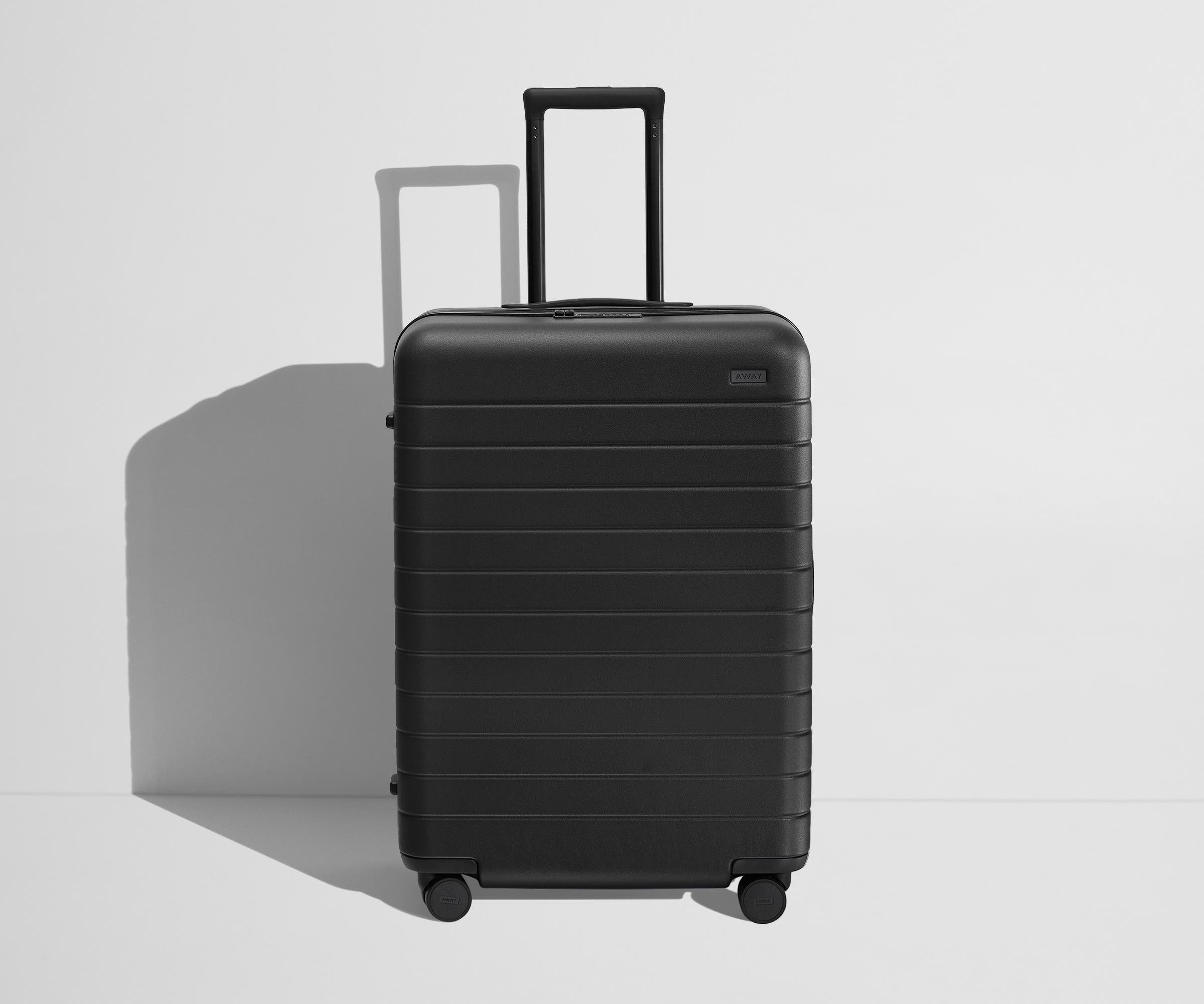 Front product view of The Medium Flex suitcase in Jet Black with raised handle