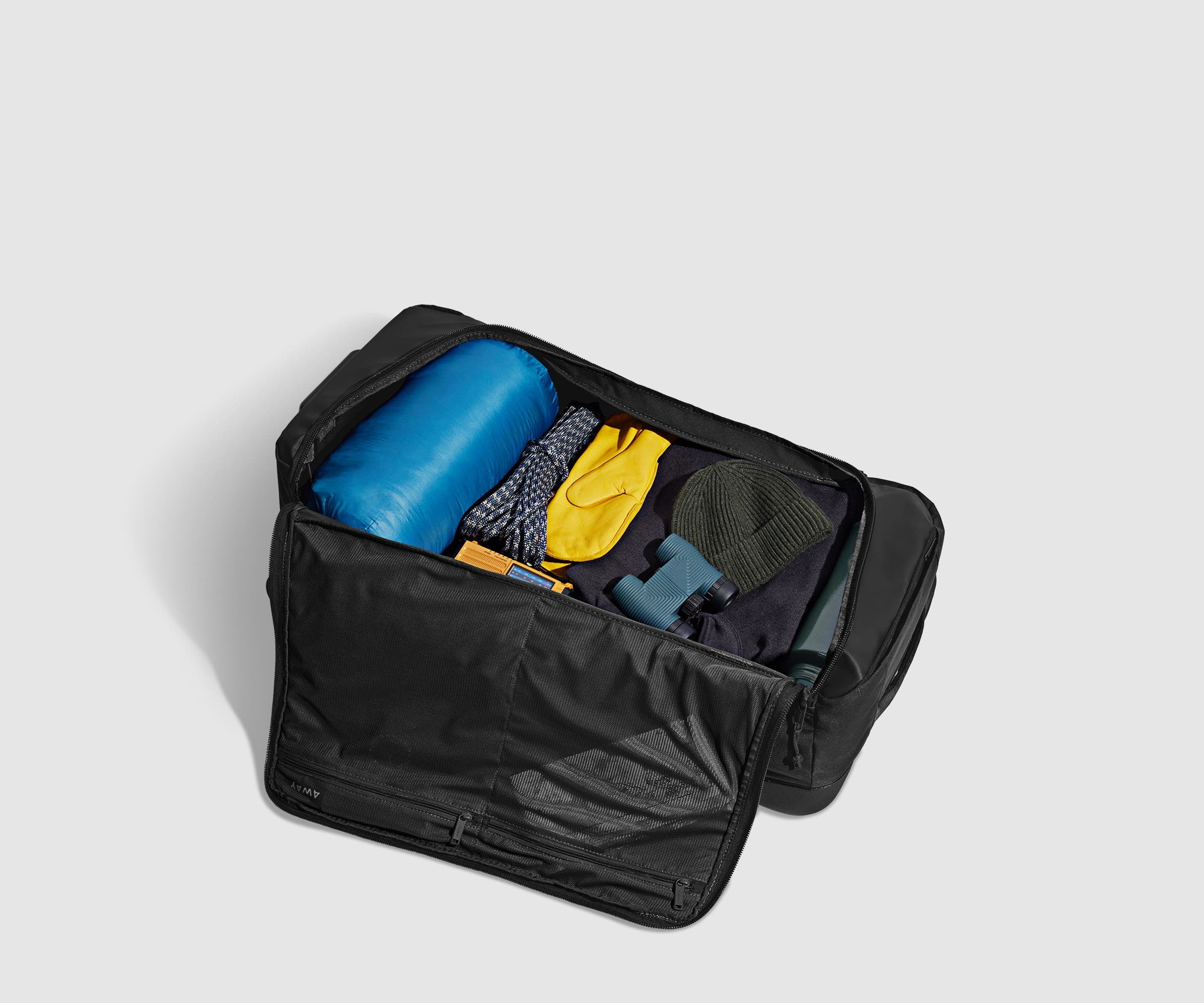 85L rolling duffle bag packed with a sleeping bag, outdoor gear, and clothing