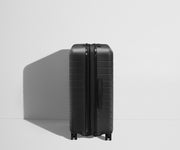 Side product view of The Medium Flex suitcase in Jet Black shown fully expanded