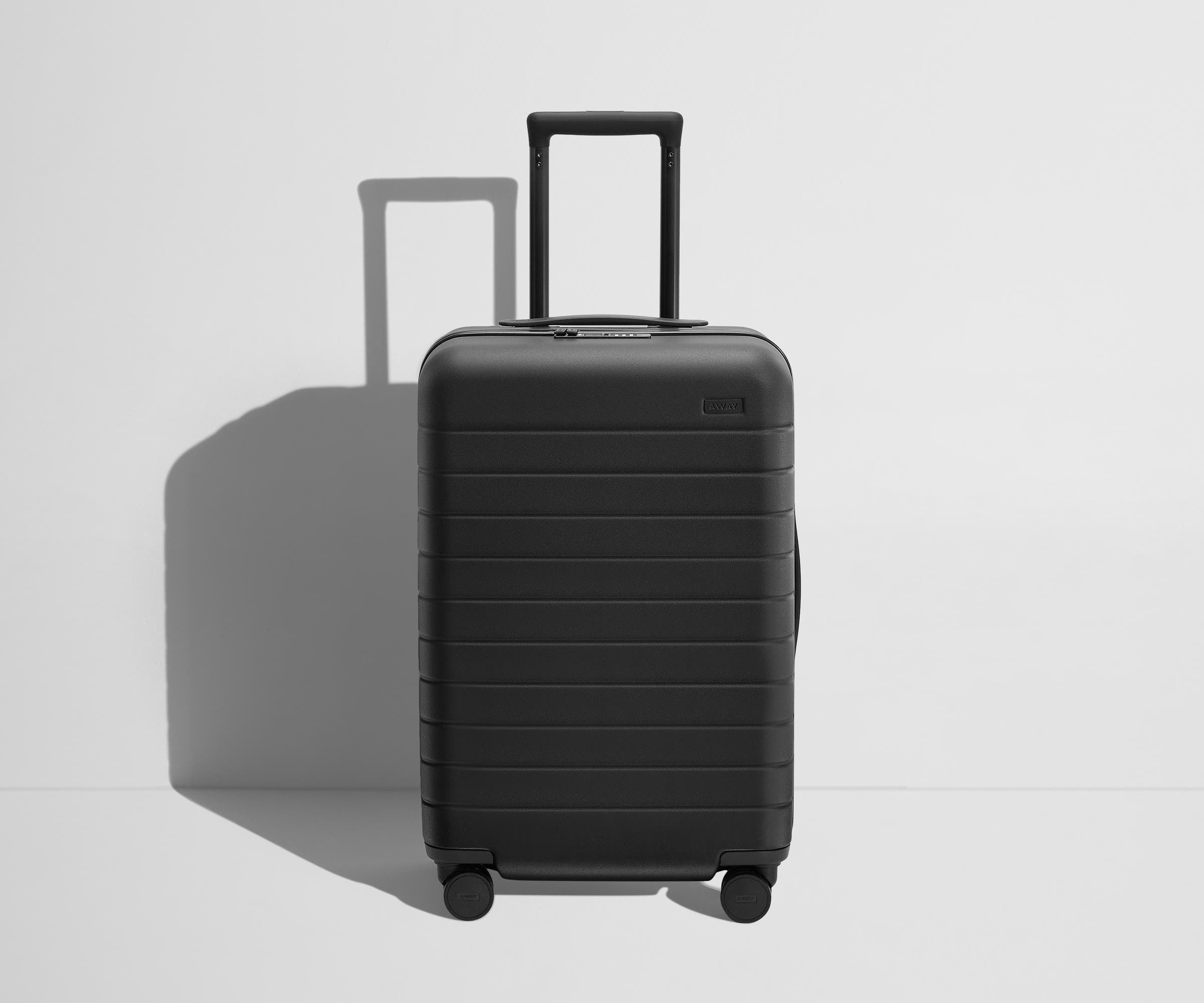 Front product view of The Bigger Carry-On Flex suitcase in Jet Black with raised handle