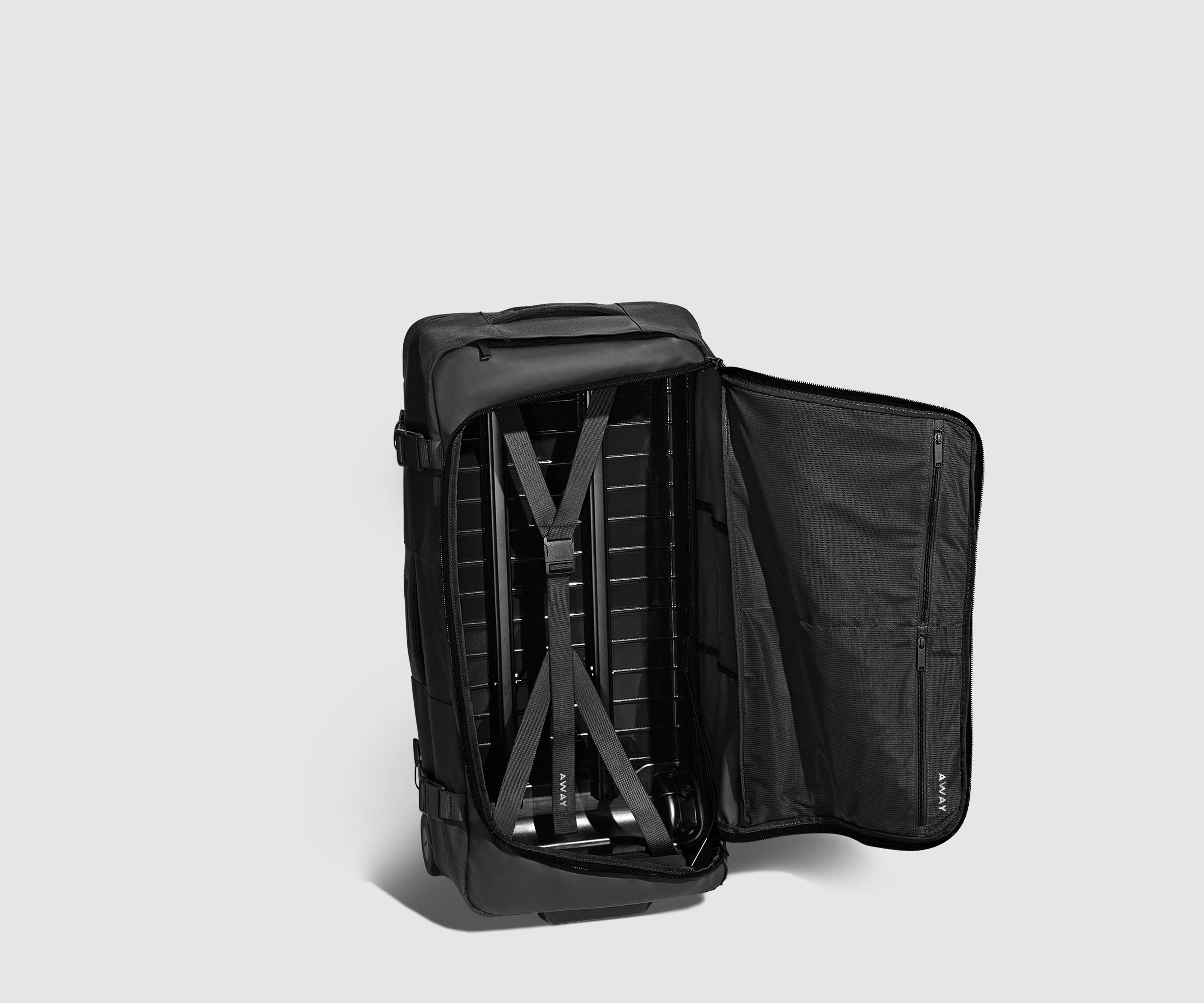 85L Duffle standing upright and unzipped, showing the compression straps and interior pockets