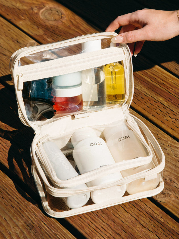 The Clear Toiletry Bag being opened and shown packed with travel-sized toiletries and products. 