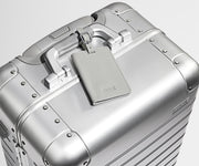 Color-matching Silver luggage tag that comes with the Aluminum suitcase