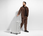 Person standing next to a Large Aluminum suitcase