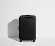 Back product view of The Bigger Carry-On Flex suitcase in Jet Black