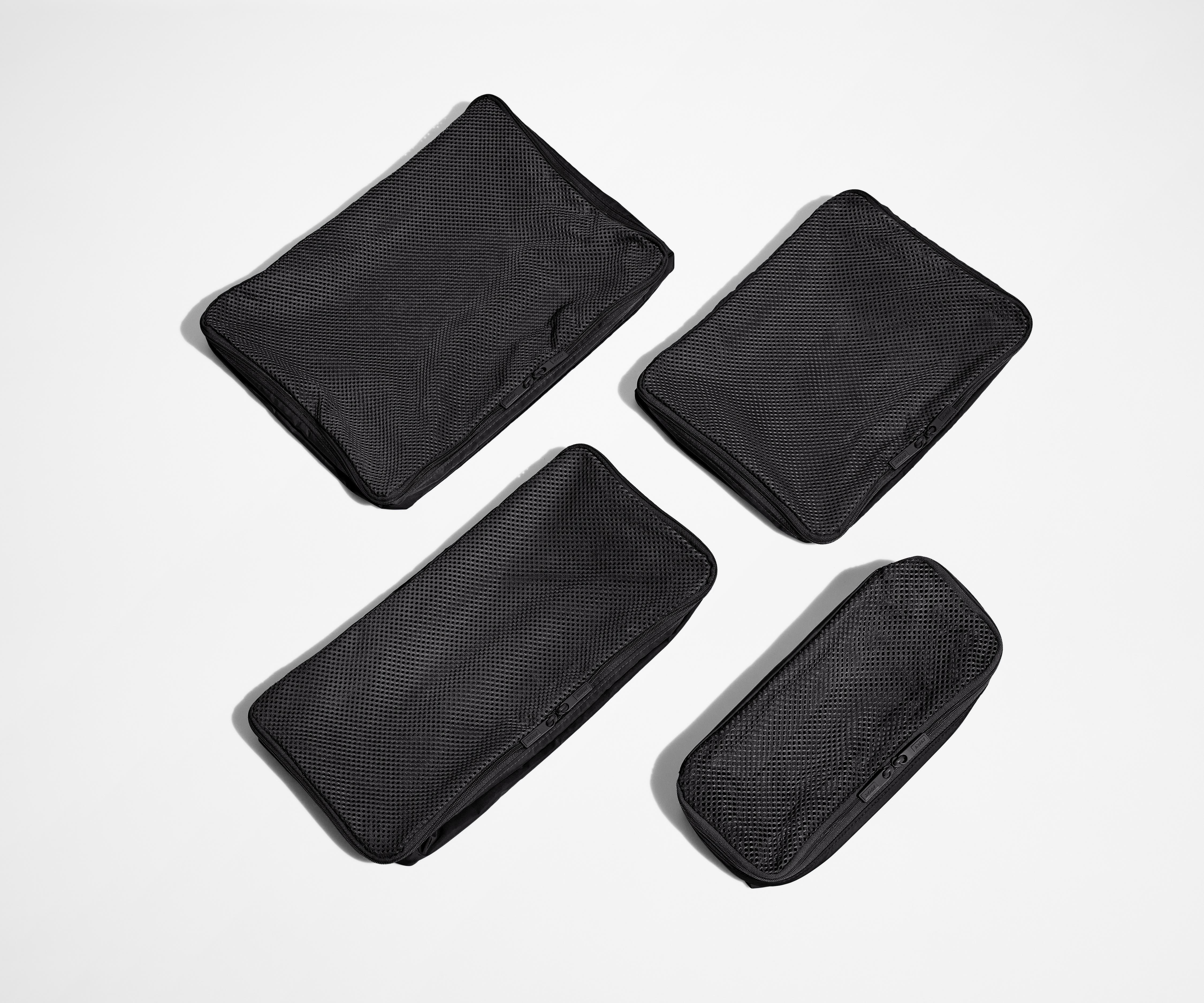 Set of four unpacked Packing Cubes laying flat