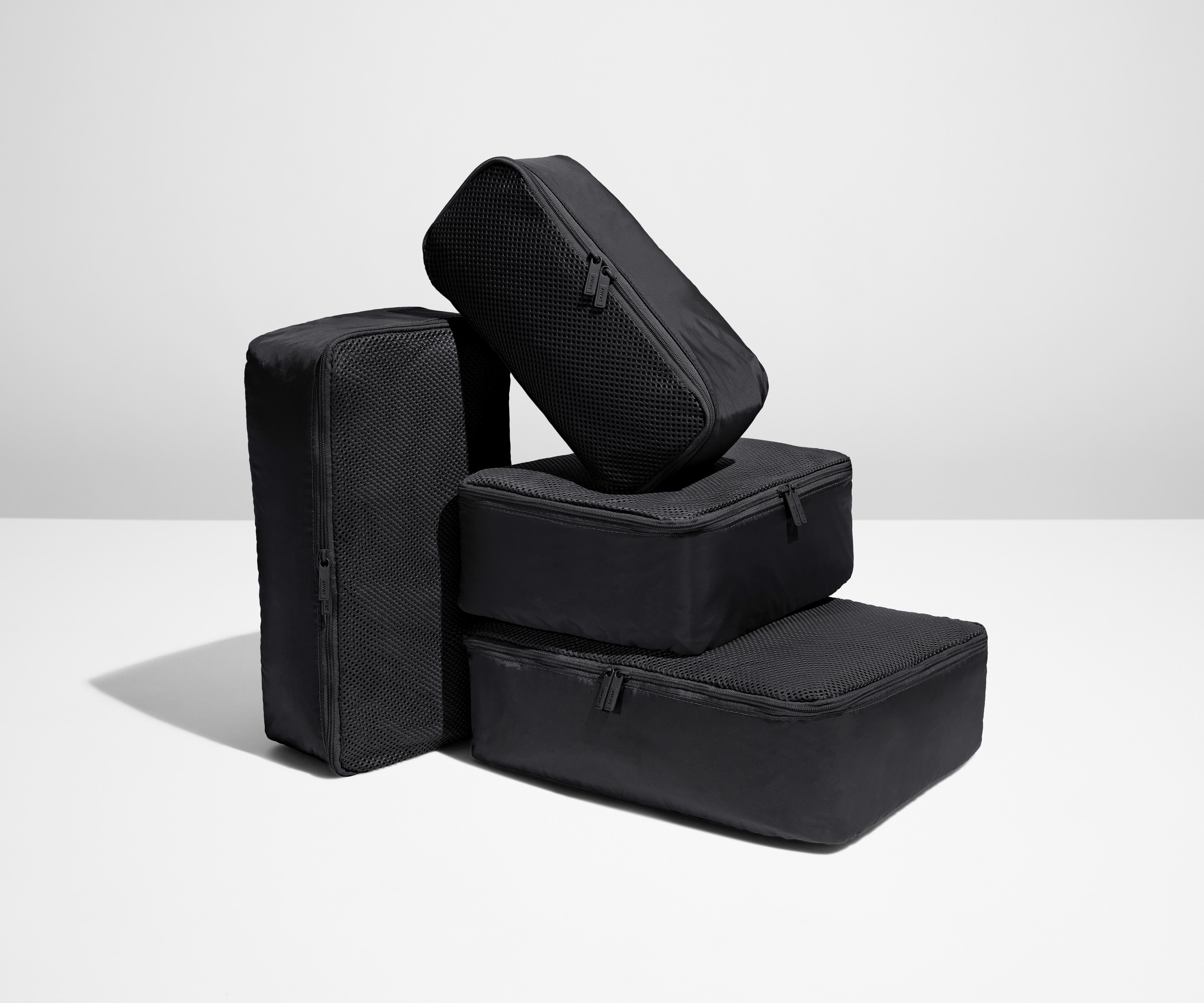 A set of four packed Insider Packing Cubes stacked on top of each other