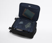 Open Softside Bigger Carry-On suitcase, with travel essentials in the front flap pocket and compression pad pockets