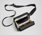 The Mini Crossbody packed with a phone, passport, and sunglasses