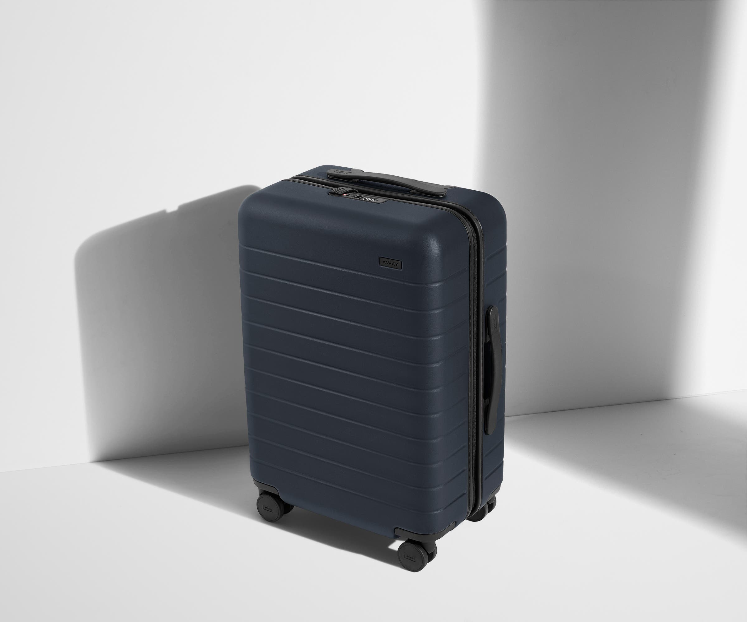 Angled product view of The Bigger Carry-On suitcase in Navy Blue